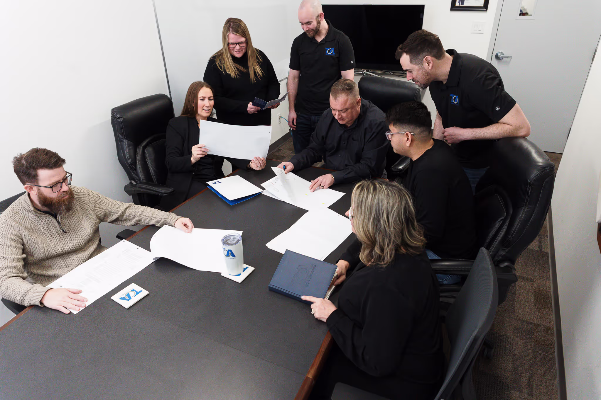 The TCA team working together around a project table